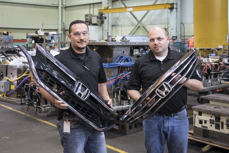 Rob Caixeiro and Joe Hindi hold an auto part produced from moulds the shop machined with Seco tooling.