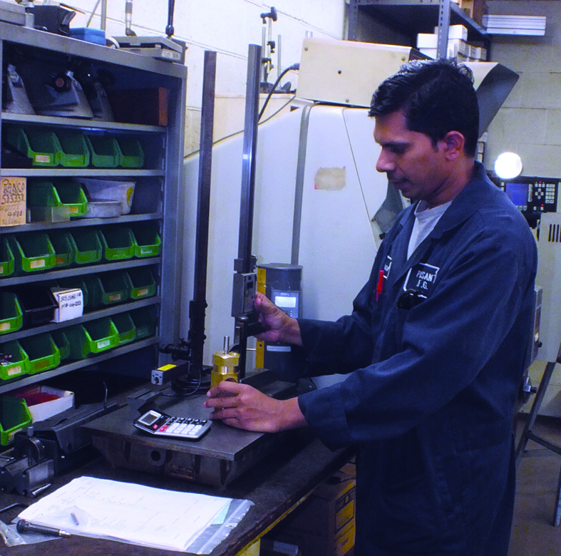 Kiran Rohit measures a part in the quality department in Pleasant Manufacturing's shop.