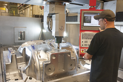 A worker at the inspection process machining verification system in Omega's facility.
