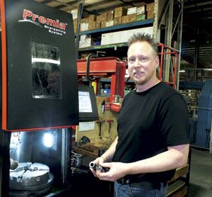 Vince Scott holding the Mate punch tooling beside an earlier investment Laicor made two years ago on a Mate Premia sharpening system, which works for dies, punches and inserts.