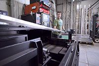 Jody Seufert, one of Reggin Industries machine operators, loads material onto the Amada ENSIS RI for processing.