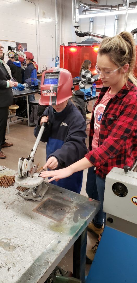 Rachel Taylor teaches grade 9 welding to students at Orangeville District Secondary School seen here helping a grade 8 MOM participant